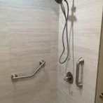 Shower wall with handheld shower and grab bars
